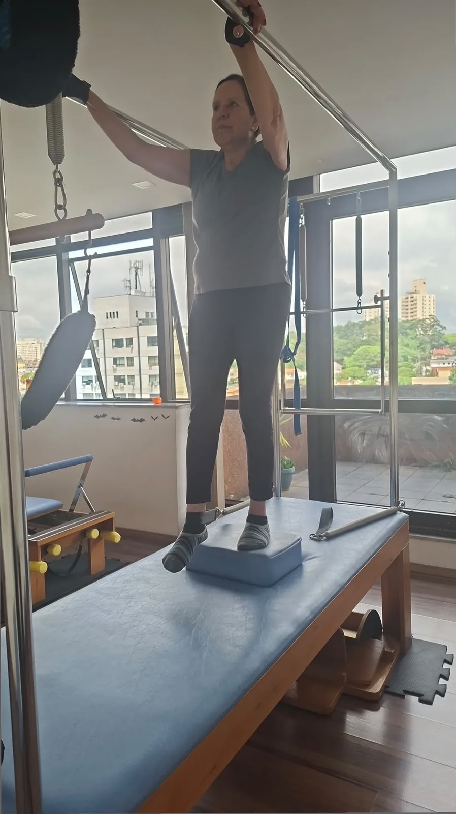 Cliente praticando Pilates em pé no Cadillac